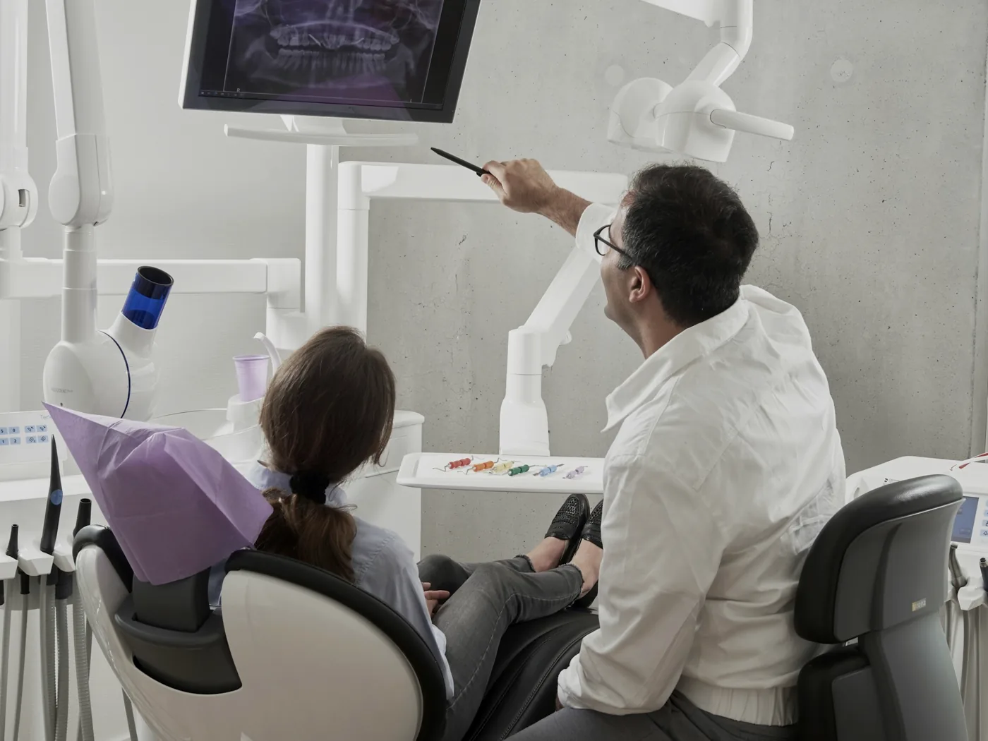 Dentista explicando um exame para a paciente na cadeira