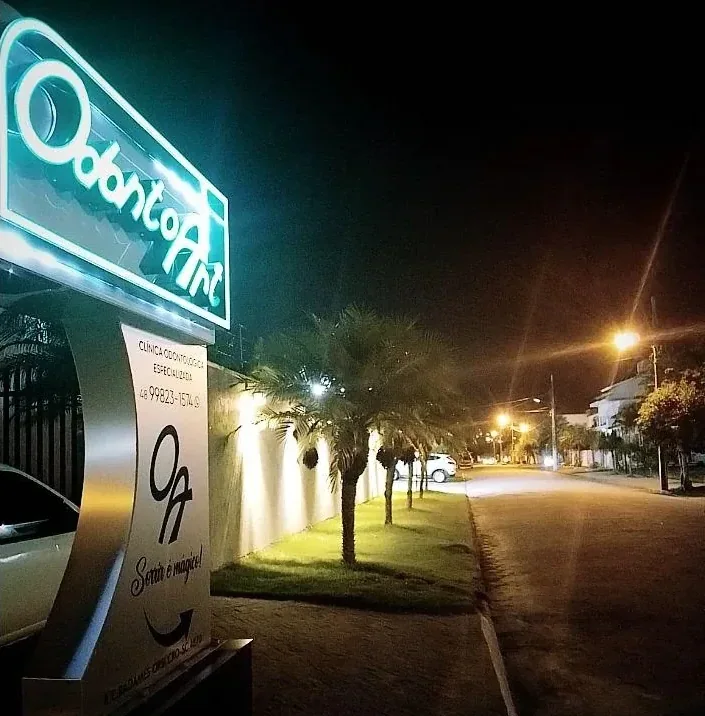 Fachada da Odonto Art à noite, com o letreiro aceso